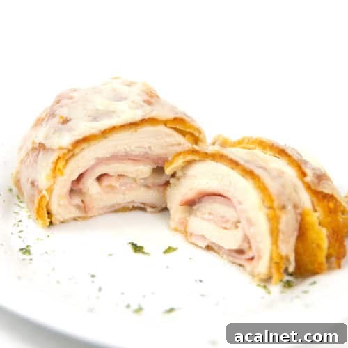 white plate of cut down the middle cordon bleu with ham and cheese inside chicken breast