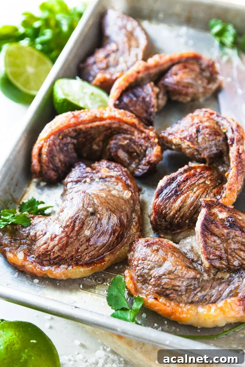 Air Fryer Picanha Steak Recipe: Perfect Crispy Crust & Juicy Center 12 Cooked picanha steak with limes and parsley on a baking sheet.