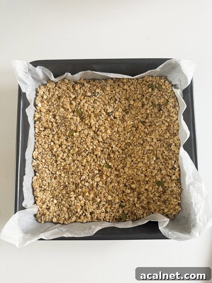 Nut-Free Oat Flapjacks Recipe — Gluten-Friendly Snack 5 Nut free flapjack in a oven dish with grease proof paper ready for the oven.