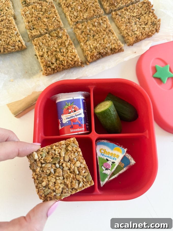 Nut-Free Oat Flapjacks Recipe — Gluten-Friendly Snack 7 One slice of nut free flapjack served in a four section bright red snack box along side a small yogurt, cucumber and cheese triangles.