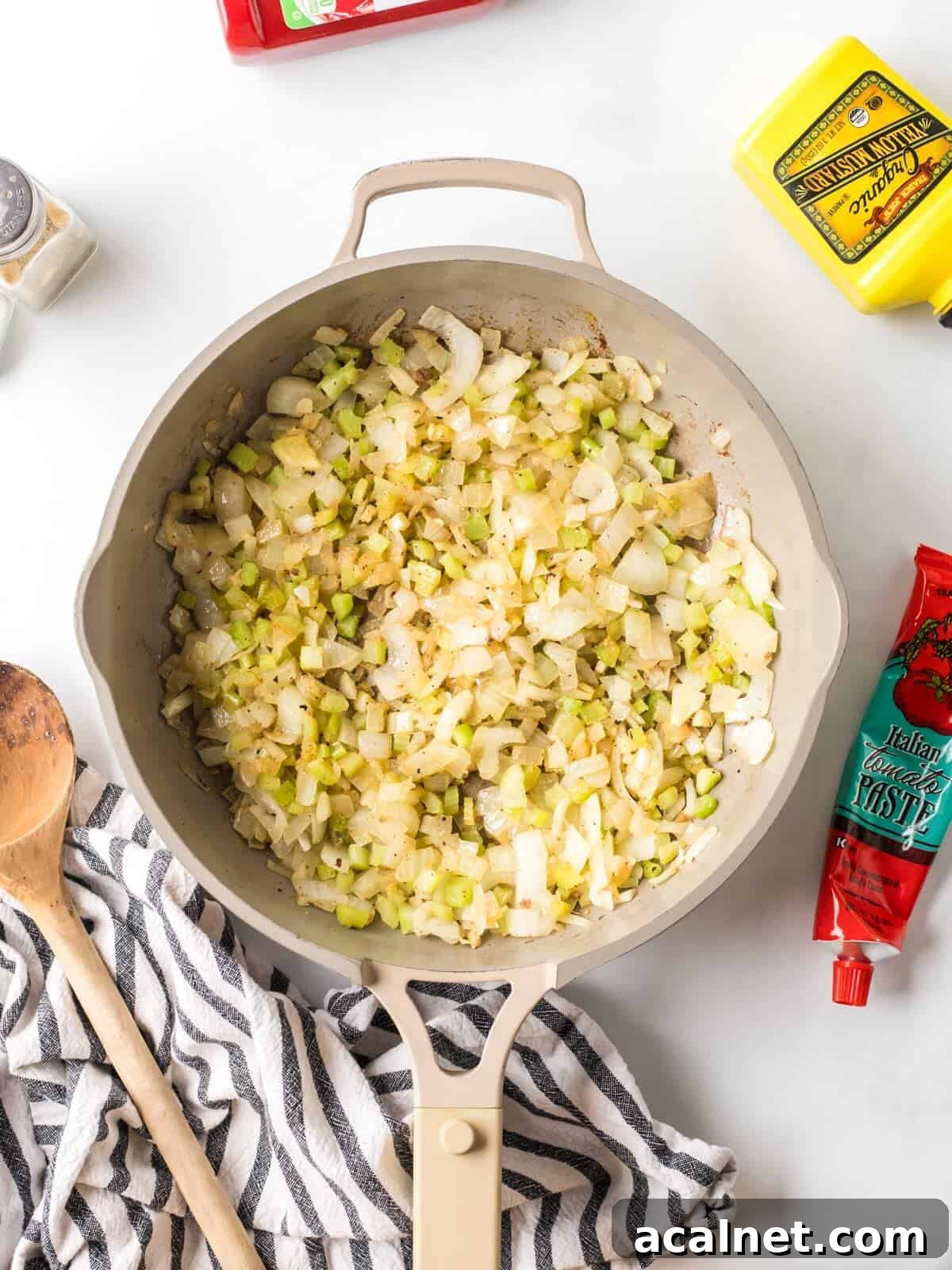 Sautéed onions, celery, and garlic in a skillet.