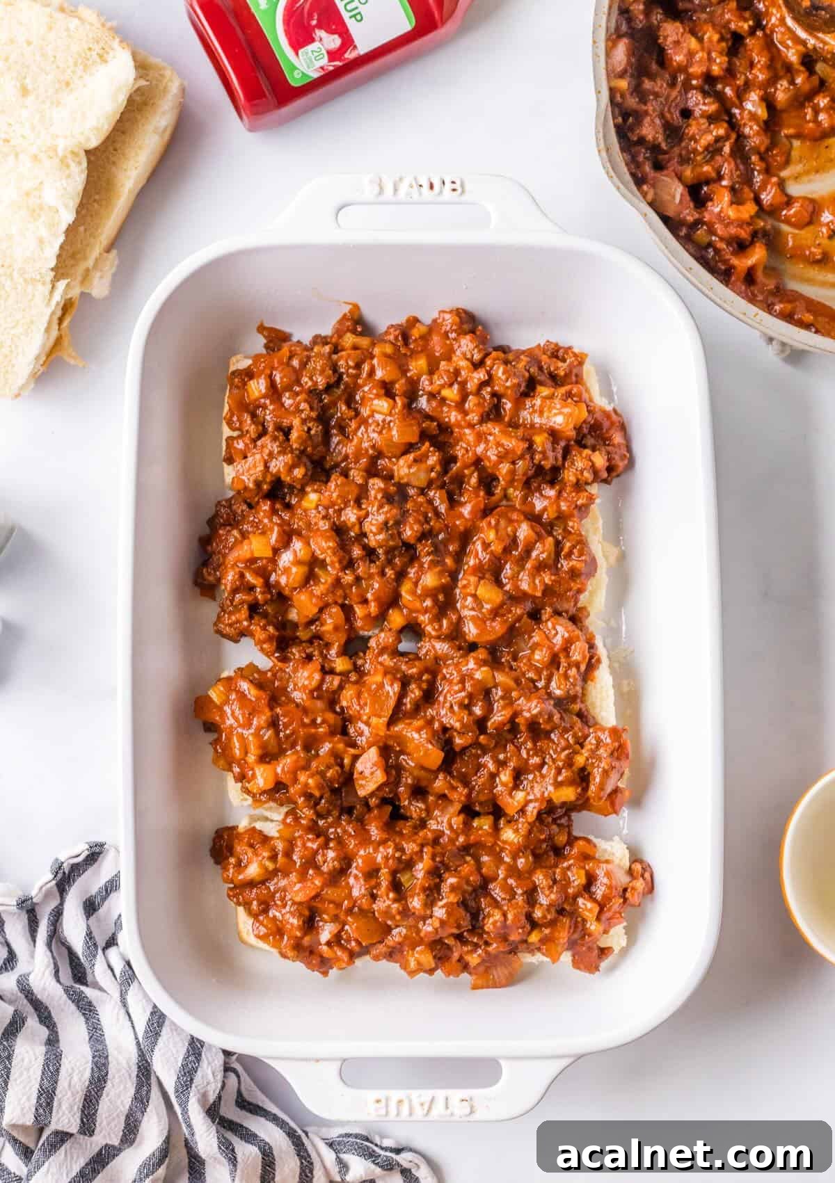 Layering ground beef filling and on Hawaiian rolls.