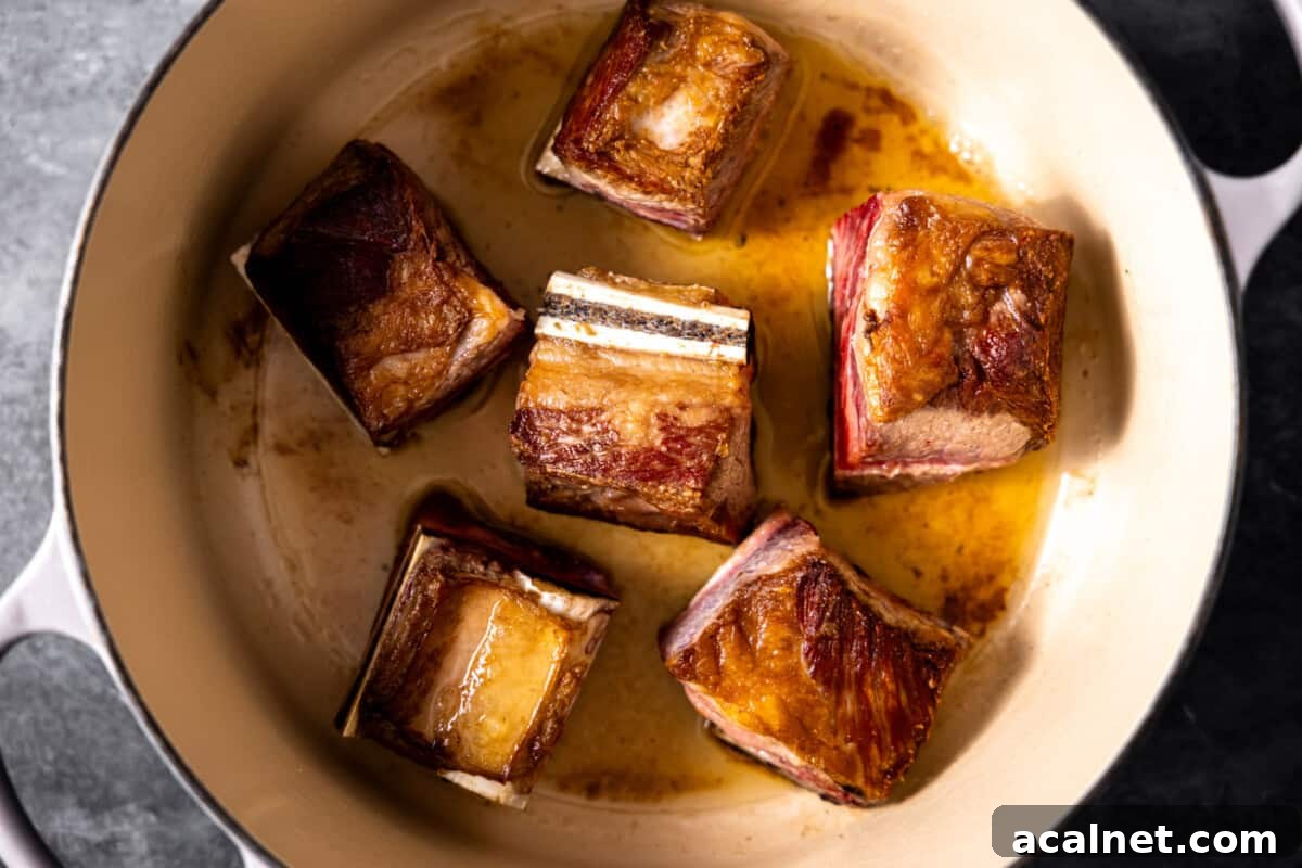 Searing bone in short ribs in a braising pan.