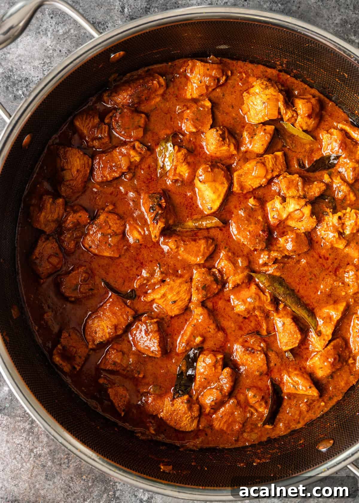 closeup overhead: chicken vindaloo recipe cooking in pan