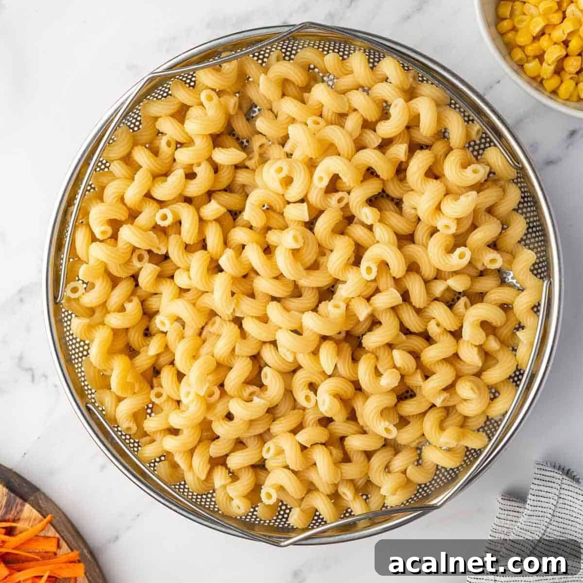 Cooked pasta is drained in a colander.