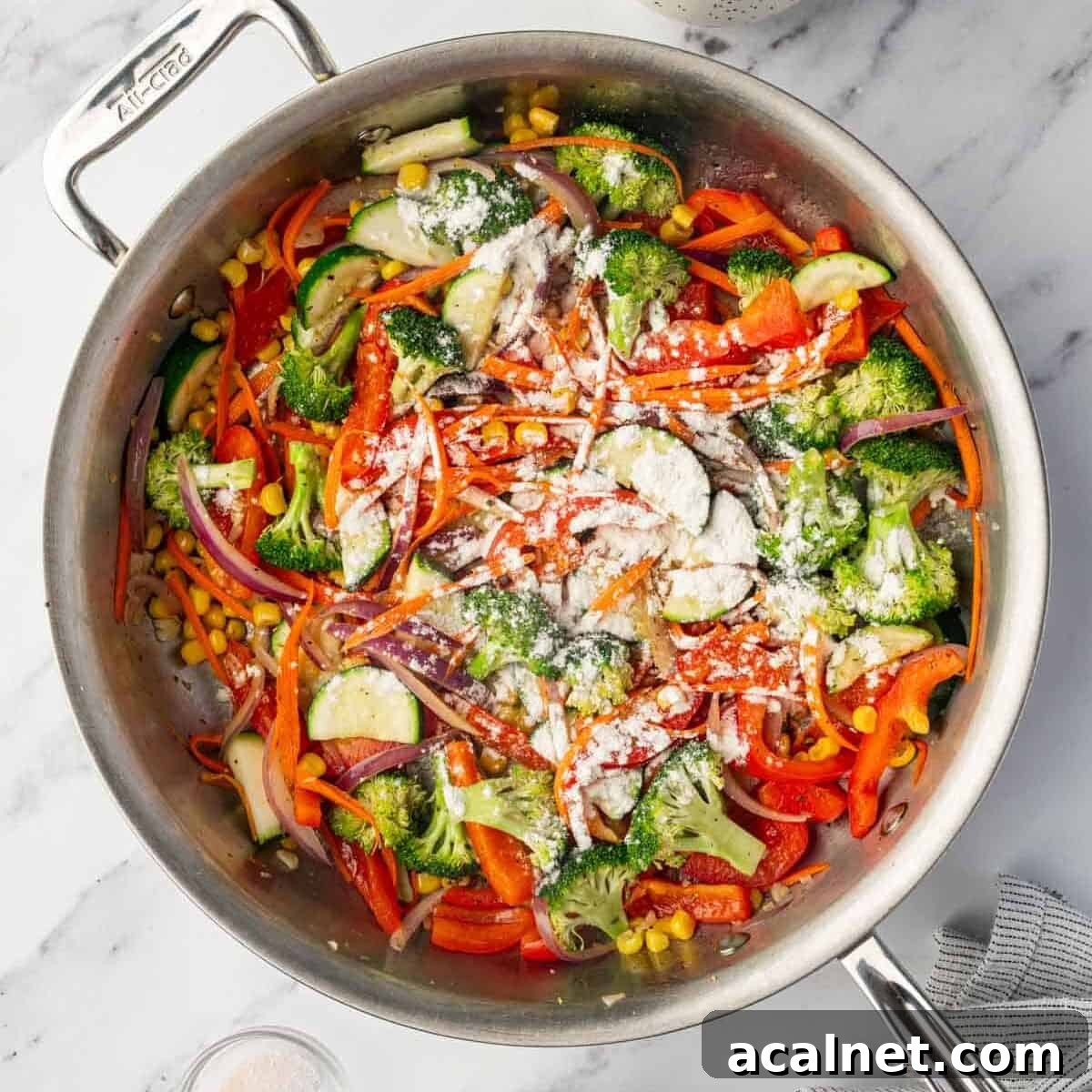 Sauted veggies are cooked for creamy pasta dish.