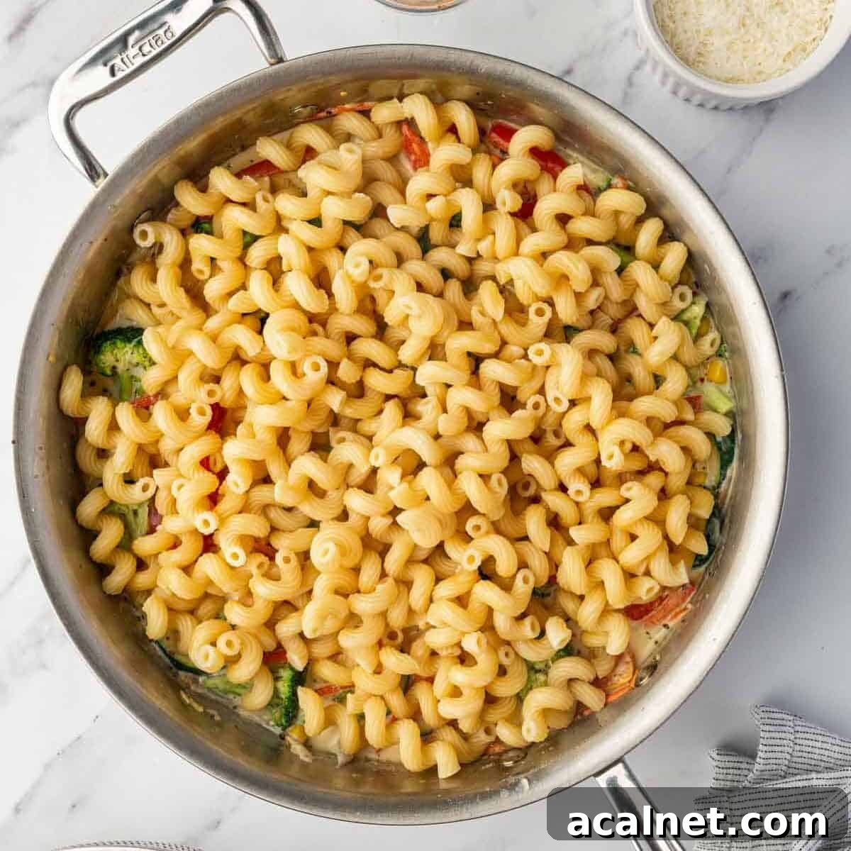 Cooked pasta is added to sauteed veggies.
