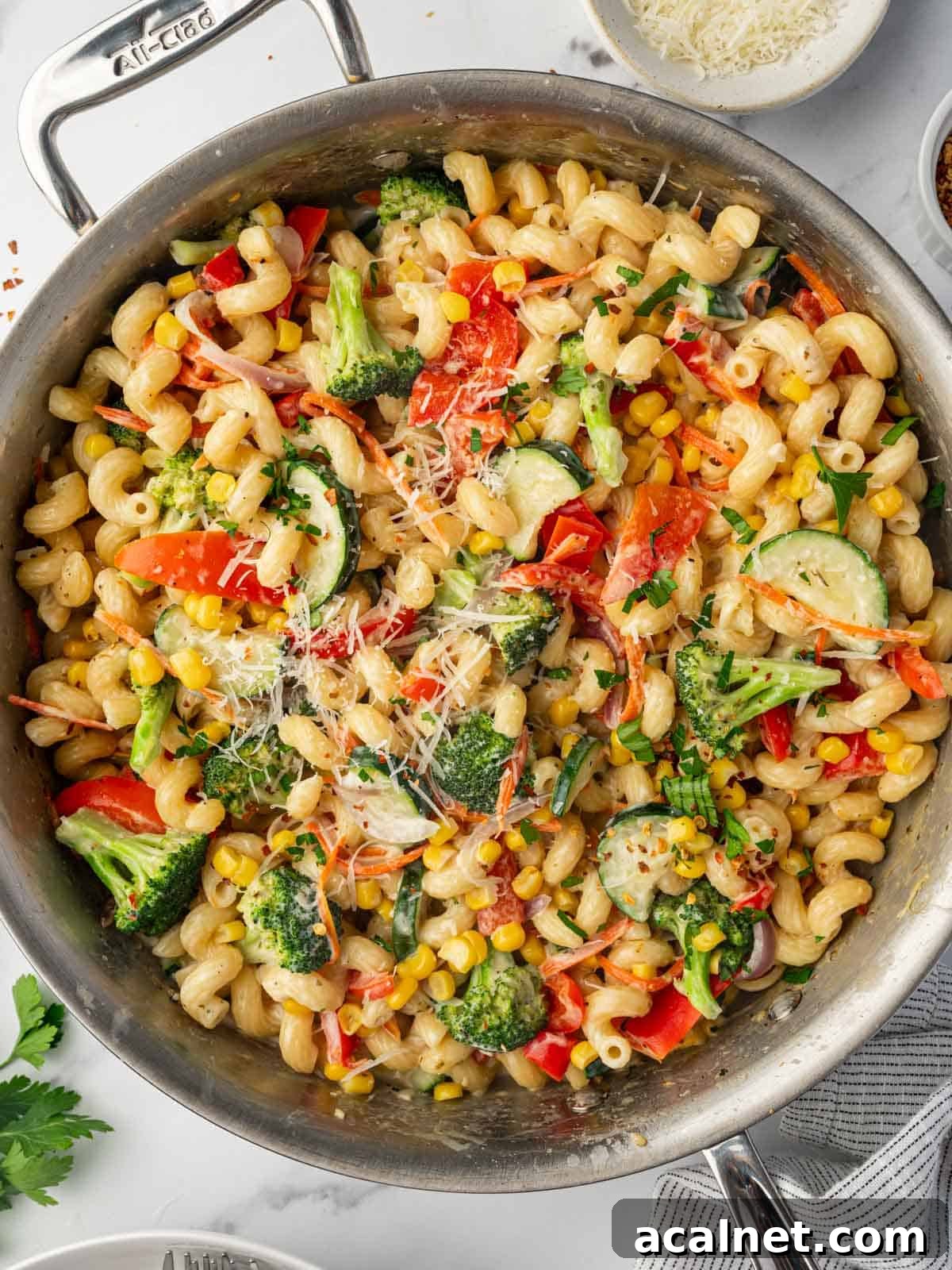 Parmasan cheese is sprinkled over veggies and pasta.