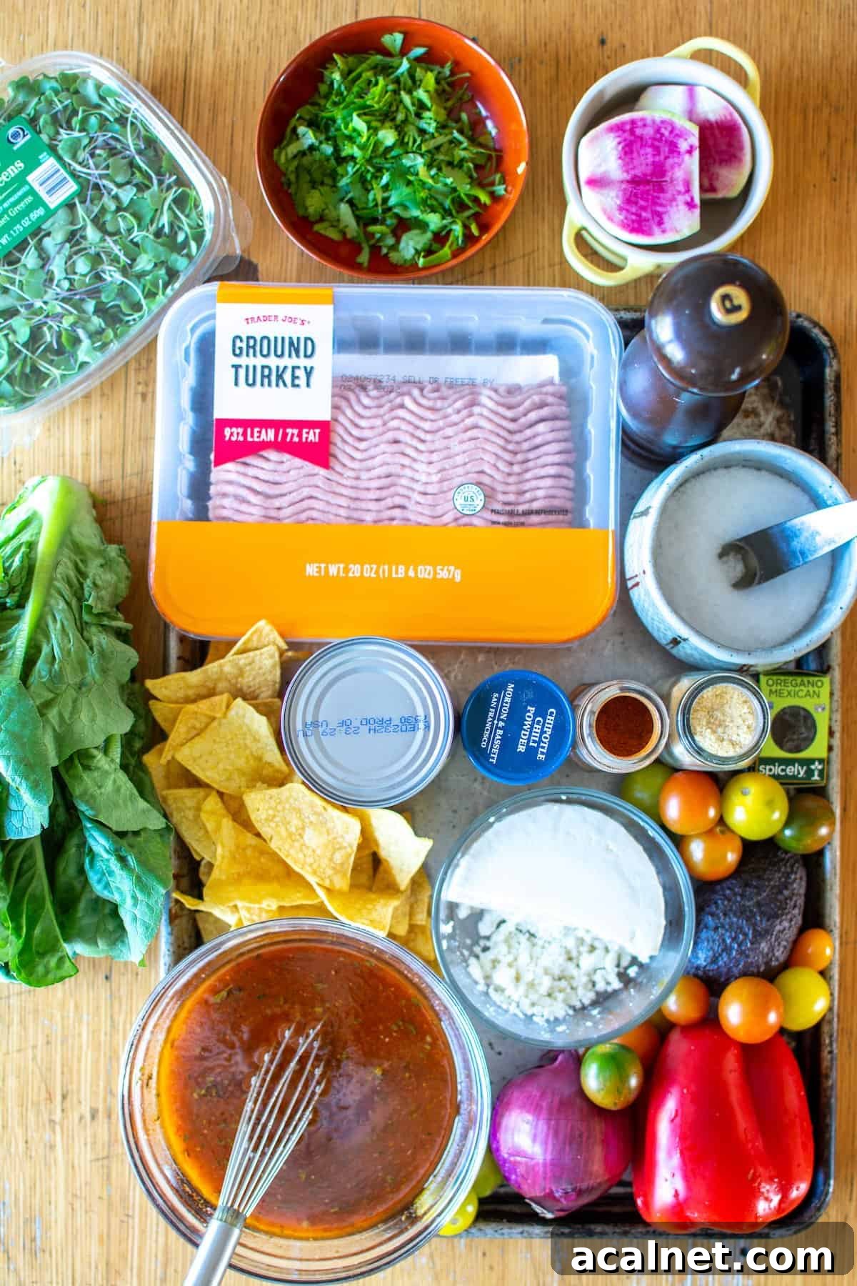 All the ingredients to make taco salad including ground turkey, micro greens, chopped cilantro, watermelon radish and more. 
