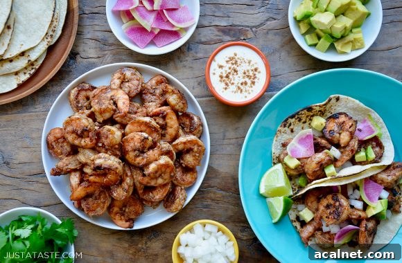 Plates and bowls containing spicy shrimp tacos, spicy shrimp, tortillas, sour cream, avocado and cilantro