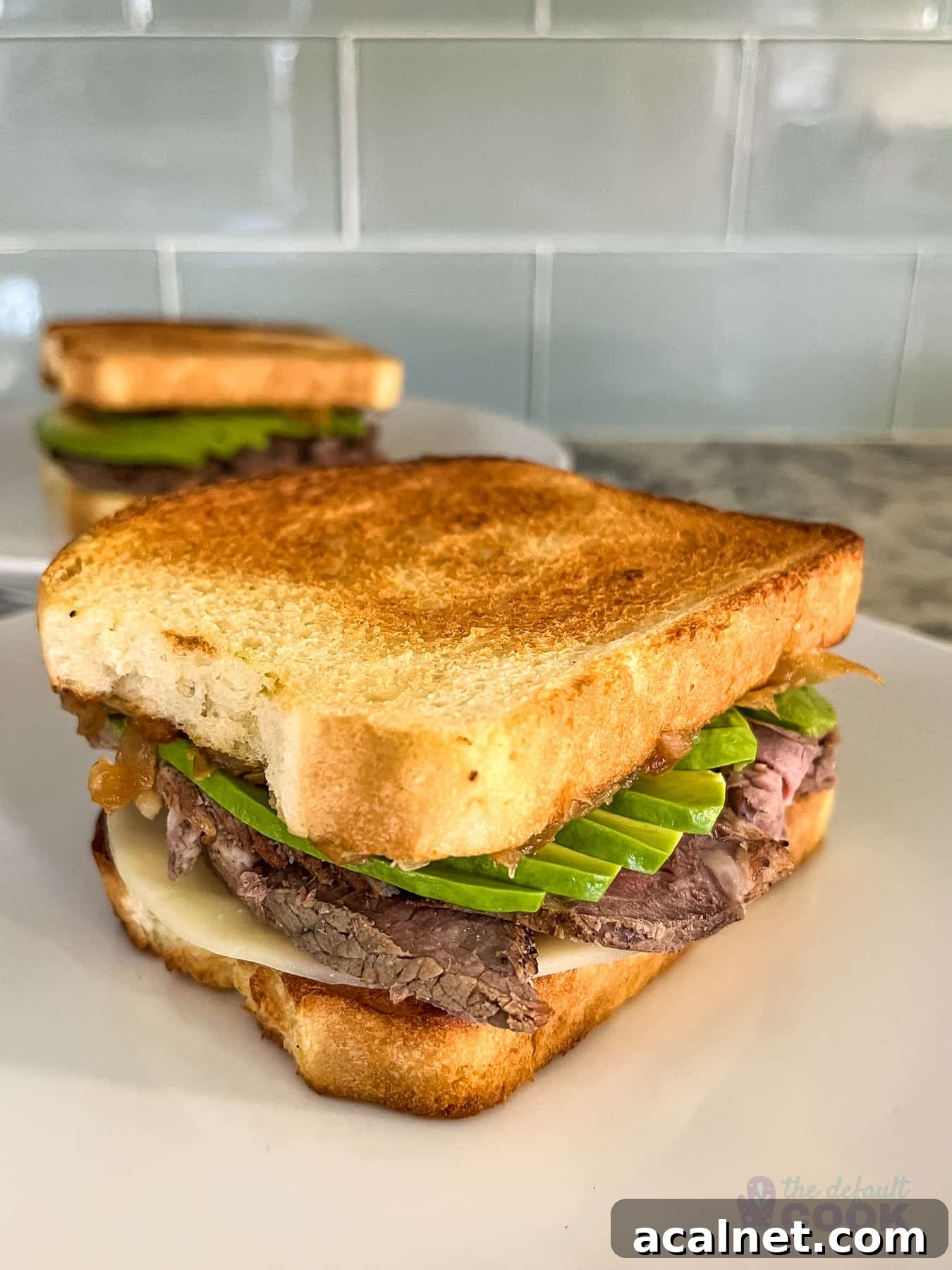 Ultimate Tri-Tip Sandwich Recipe: Juicy Steak Sandwich Guide 2 Two sandwiches on white plates with one in front of the other.