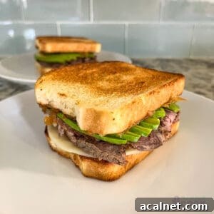 Ultimate Tri-Tip Sandwich Recipe: Juicy Steak Sandwich Guide 8 Two leftover tri tip sandwiches on white plates on counter with green backsplash.