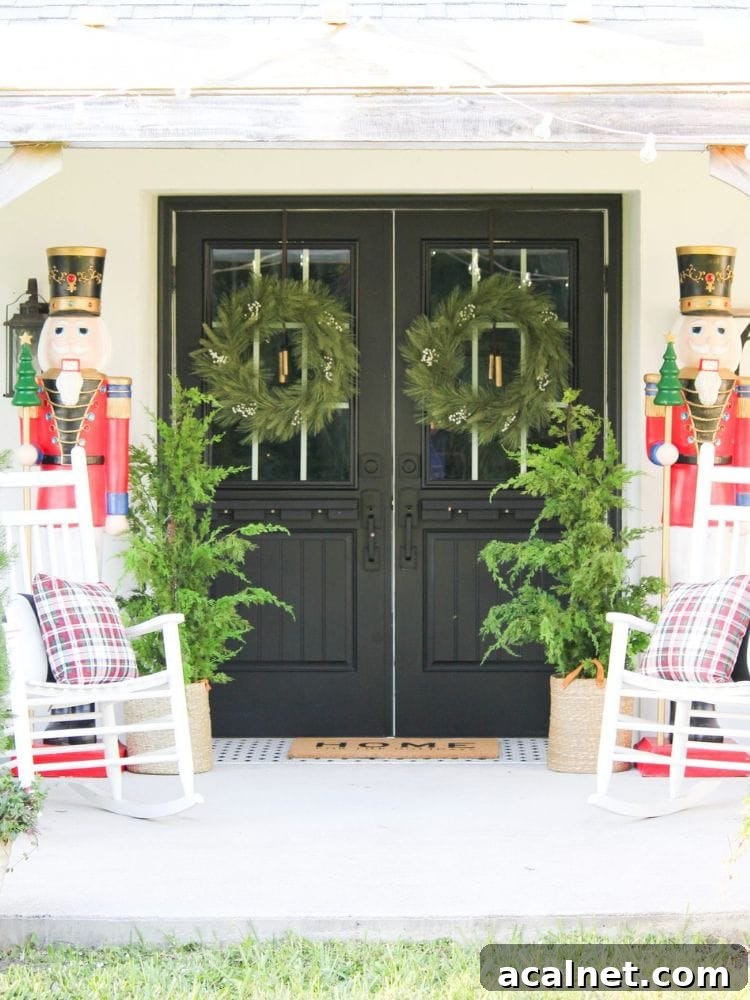 Front entry with double doors decorated for Christmas with two life-size nutcracker figures, wreaths, and potted evergreens