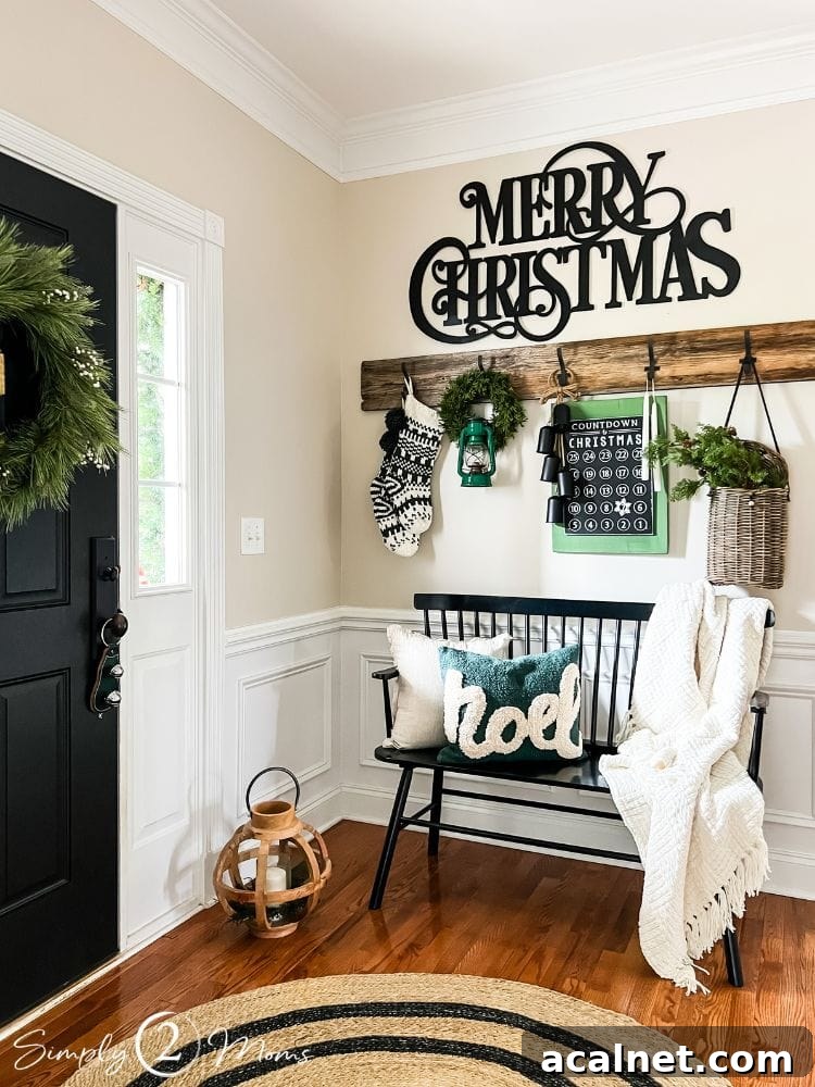 Foyer decorated for Christmas with farmhouse style hooks above a black bench with green and white decor.