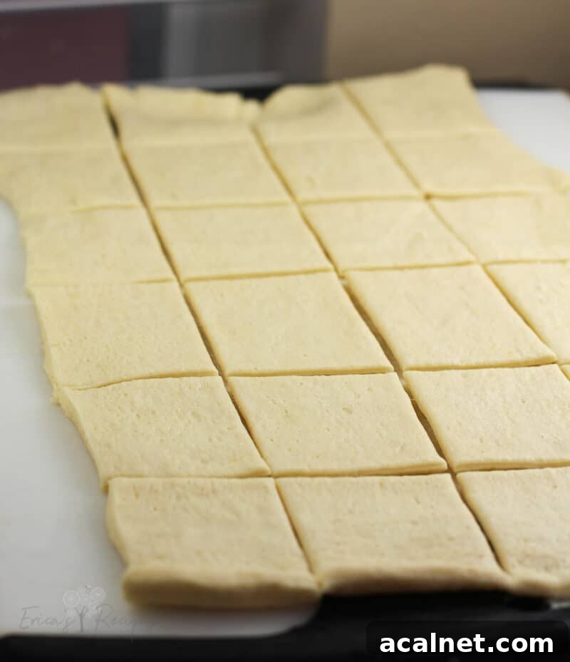 crescent dough sheet on white board cut into 24 squares
