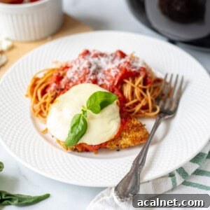 Crispy Air Fryer Chicken Parmesan Recipe 2 Air Fryer Chicken Parmesan on white plate served with side of spaghetti.
