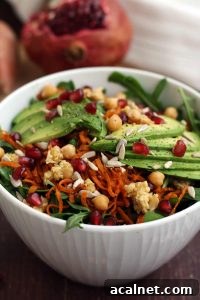 Healthy Sweet Potato Noodle Salad with Chickpeas and Rocket - Bowl Closeup with a Pomegranate in the Background
