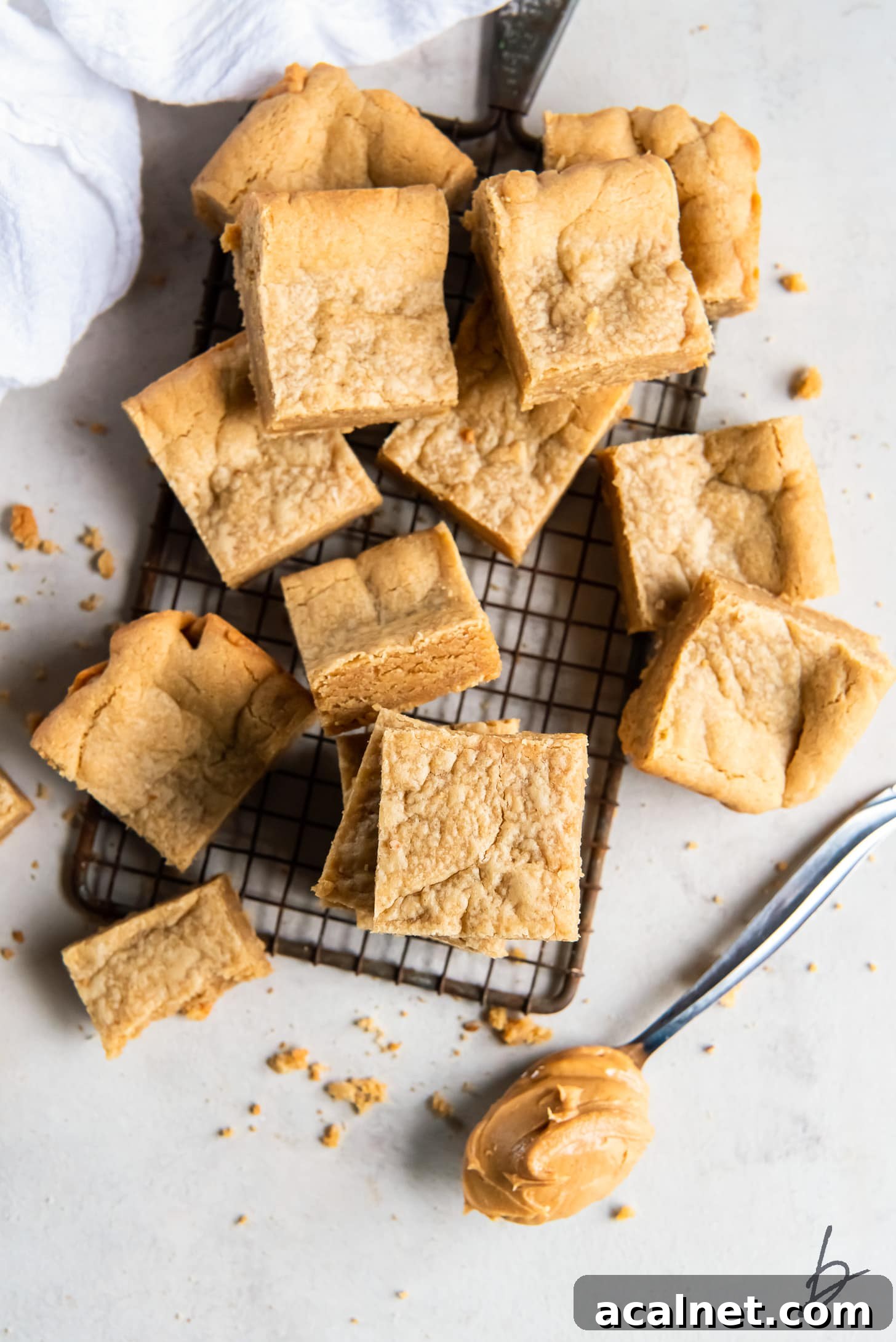 Chewy Peanut Butter Cookie Bar Recipe for Busy Bakers 5 peanut butter cookie bars piled on small wire cooling rack.