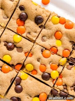 reeses pieces peanut butter blondies cut into squares on parchment paper