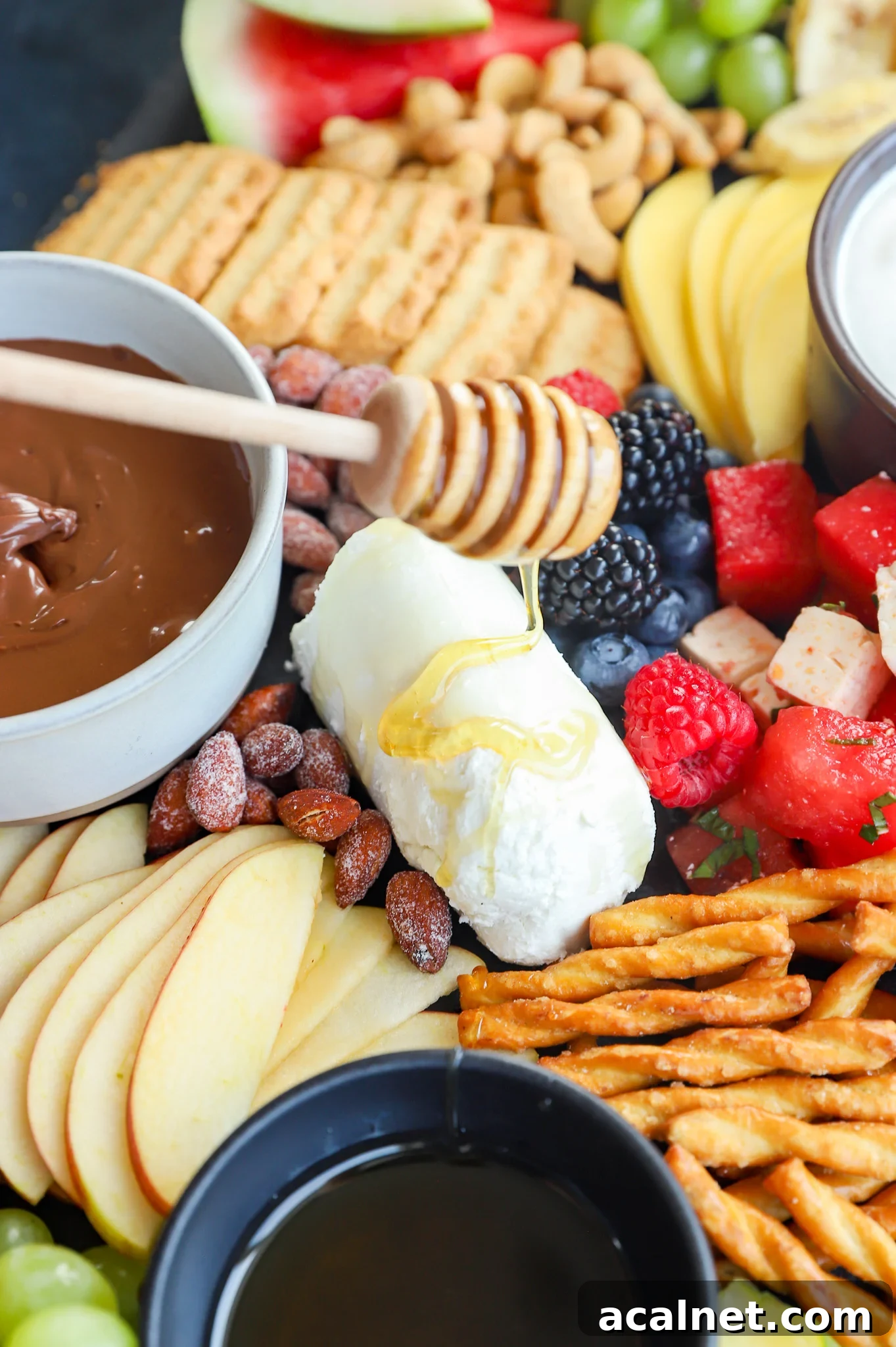 Fresh Fruit Charcuterie Board Ideas for Entertaining 8 Drizzling honey on goat cheese for a cheese platter image