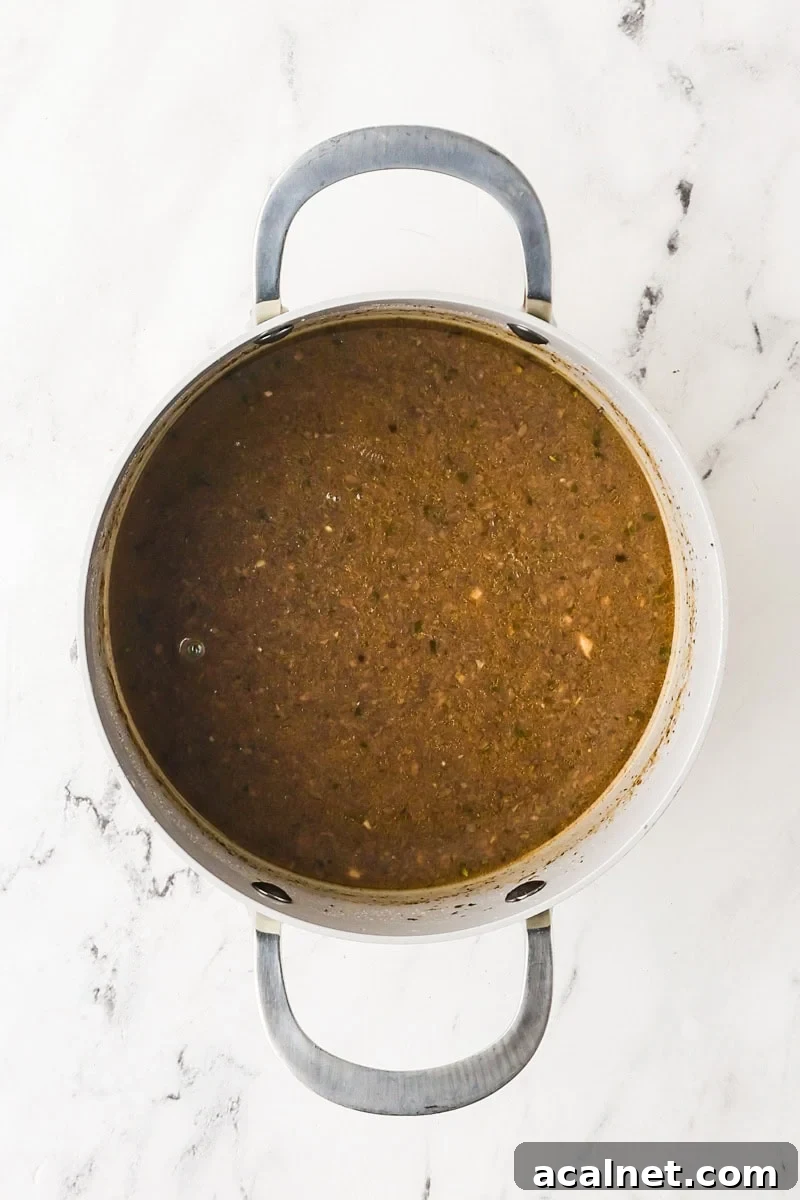 Vegan mushroom gravy simmering in a saucepan.