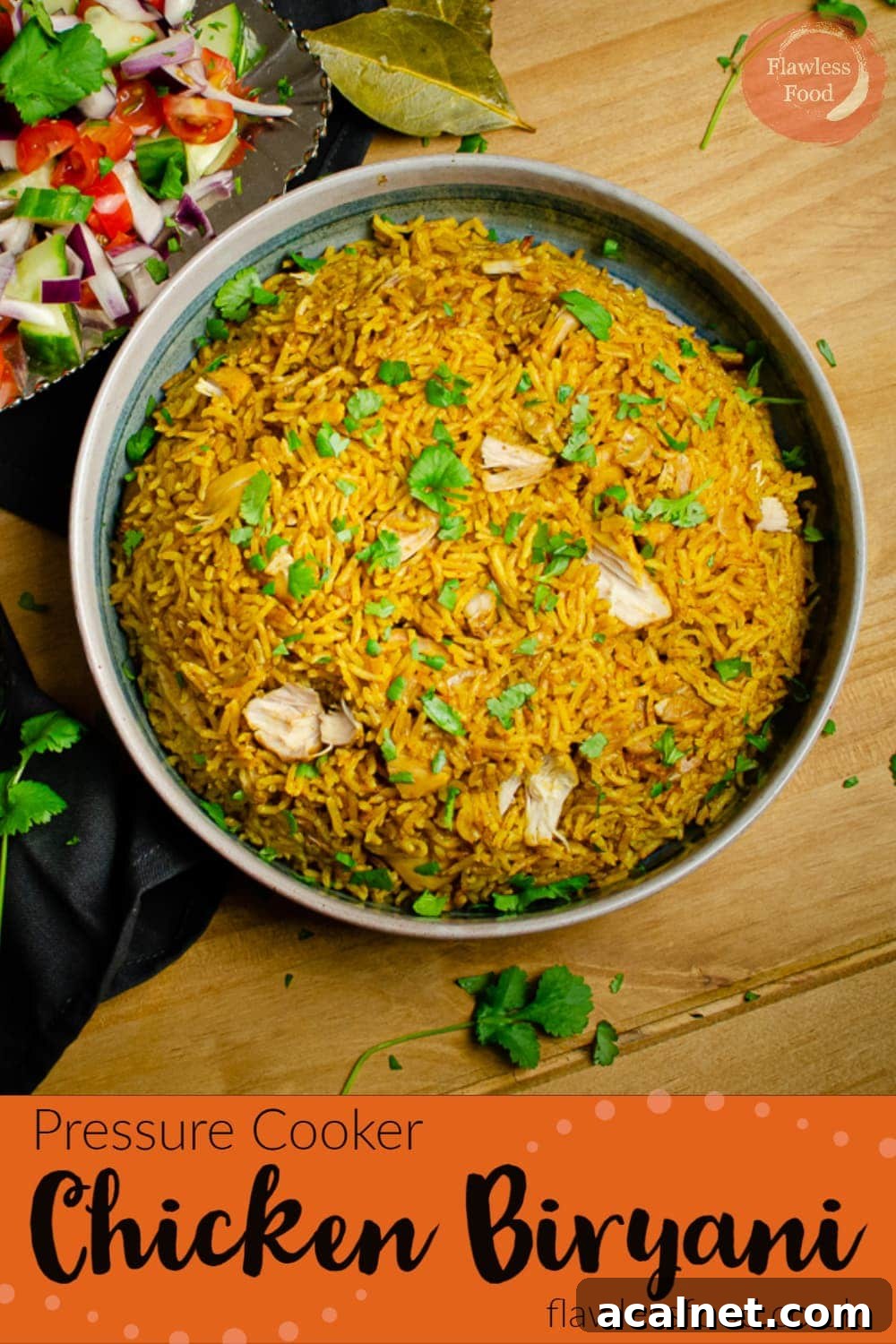 Pressure cooker Chicken Biryani served in a green bowl with salad on the side on a wooden table for a Pinterest image
