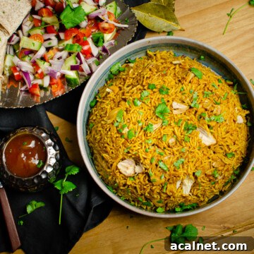 Pressure cooker Chicken Biryani served in a green bowl with chopped coriander on top, salad and mango chutney served on the side