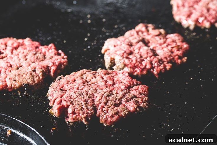 Crispy Flat-Top Cheeseburger Recipe with Caramelized Onions 3 flat top patties on griddle
