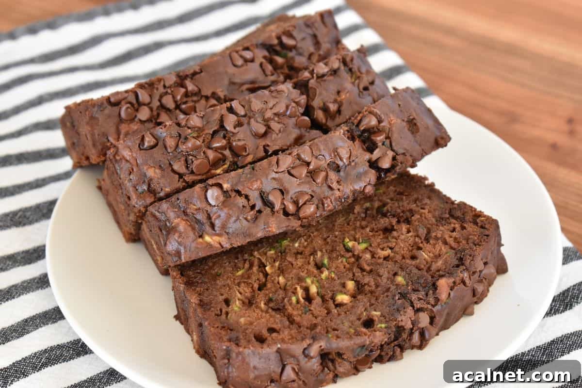 Chocolate Zucchini Banana Bread Recipe: Moist Loaf with Cocoa and Banana 3 Chocolate zucchini banana bread sliced on a white plate with mini chocolate chips on top.