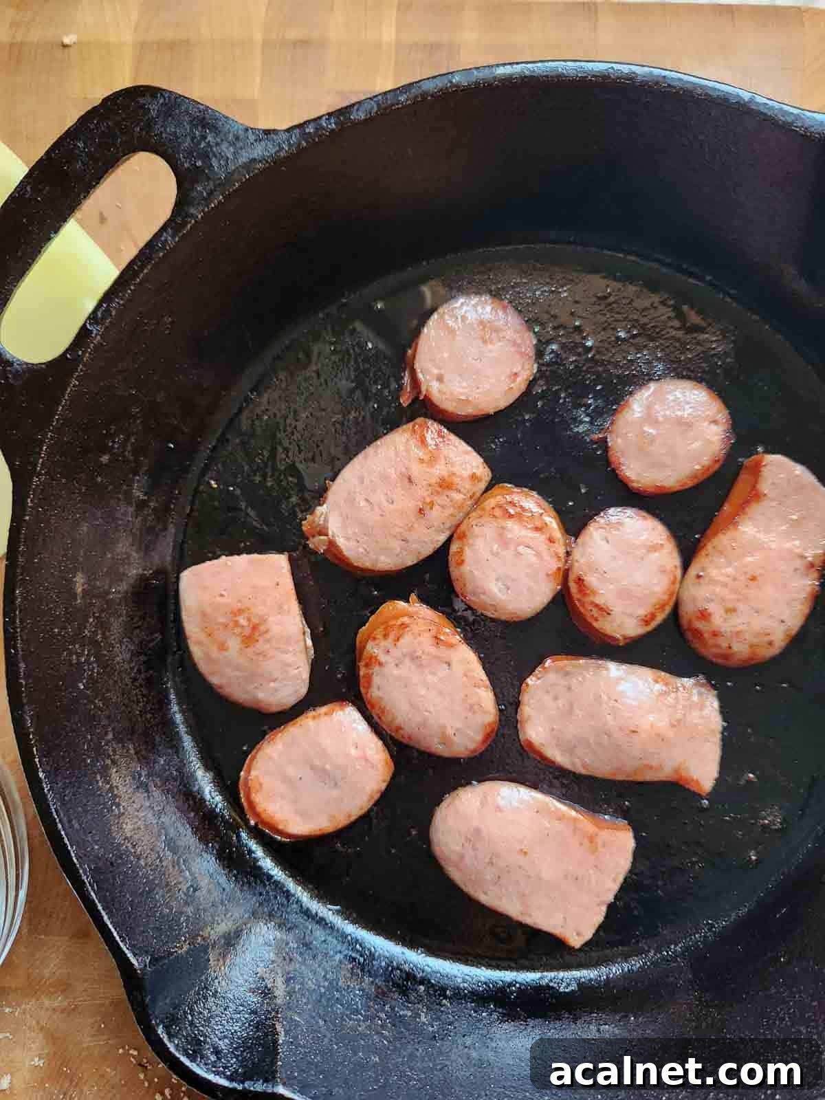 Kielbasa Reuben Sandwich Recipe — Smoky Sausage & Sauerkraut Melt 4 Fried kielbasa sausage in a cast iron skillet.