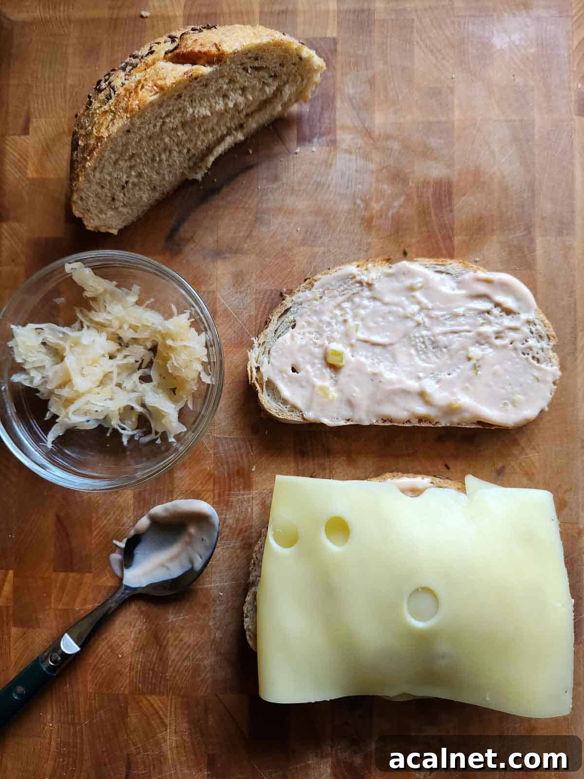 Kielbasa Reuben Sandwich Recipe — Smoky Sausage & Sauerkraut Melt 8 Bread, sauerkraut and cheese on a cutting board.