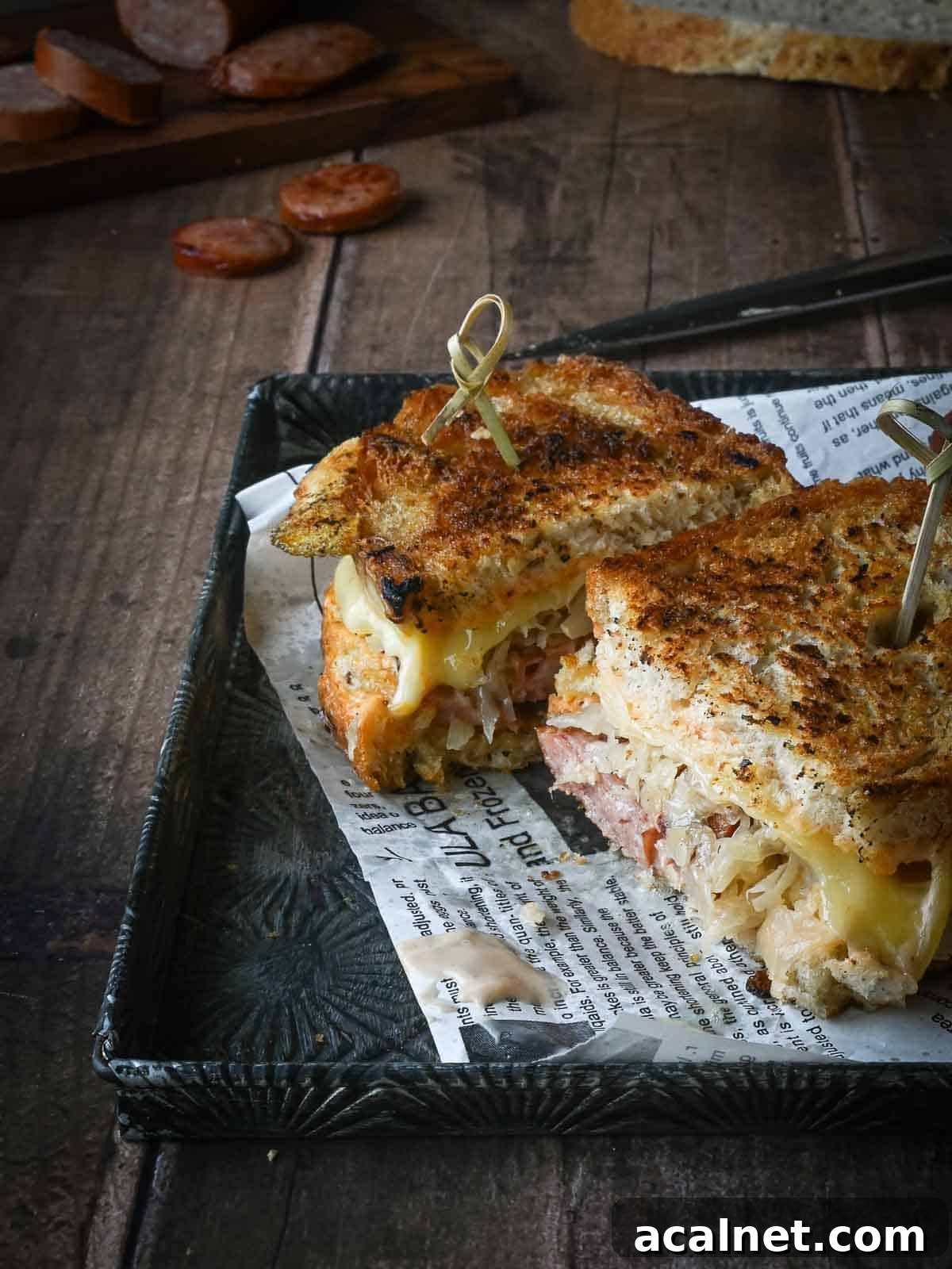 Kielbasa Reuben Sandwich Recipe — Smoky Sausage & Sauerkraut Melt 10 Kielbasa sandwich sliced in half on a wood table.