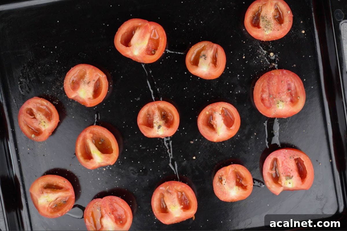 Tomato halves arranged on a baking tray and drizzled with extra virgin olive oil, salt and pepper.