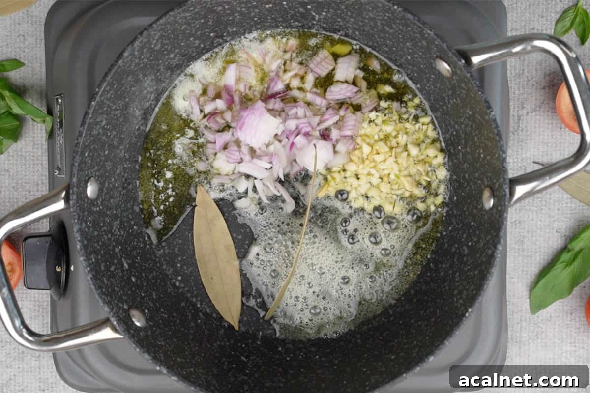 Garlic, onions and bay leaves added to the pan.