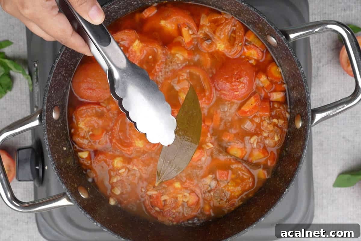 Discarding the bay leaves using a pair of tongs.