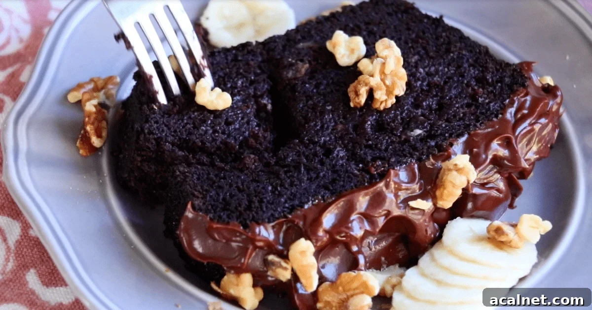 A slice of soft chocolate banana cake with sliced banana and toasted walnut on a plate.