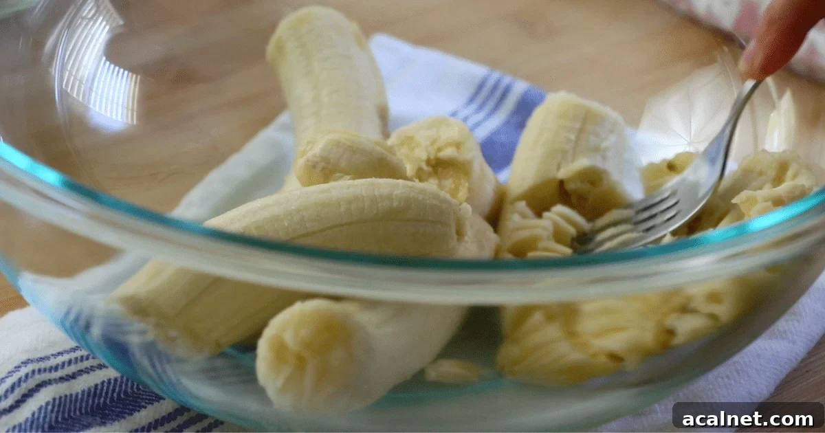 Mashing ripe bananas in a bowl.