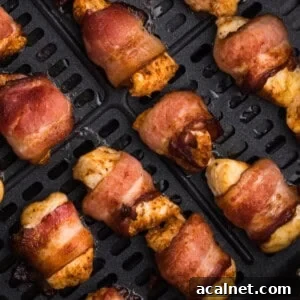 air fried bacon wrapped chicken bites in the basket of the air fryer.