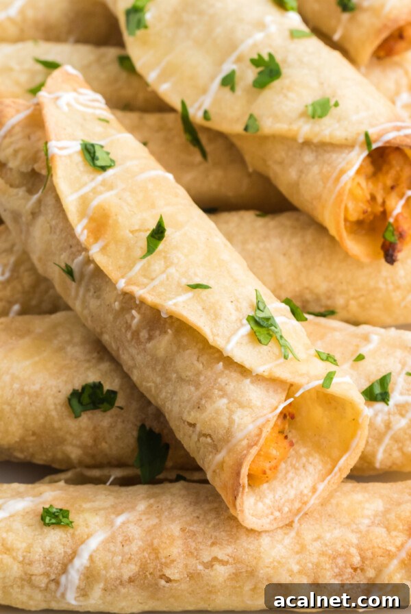 Chicken taquitos made in the air fryer and topped with sour cream and cilantro before serving.