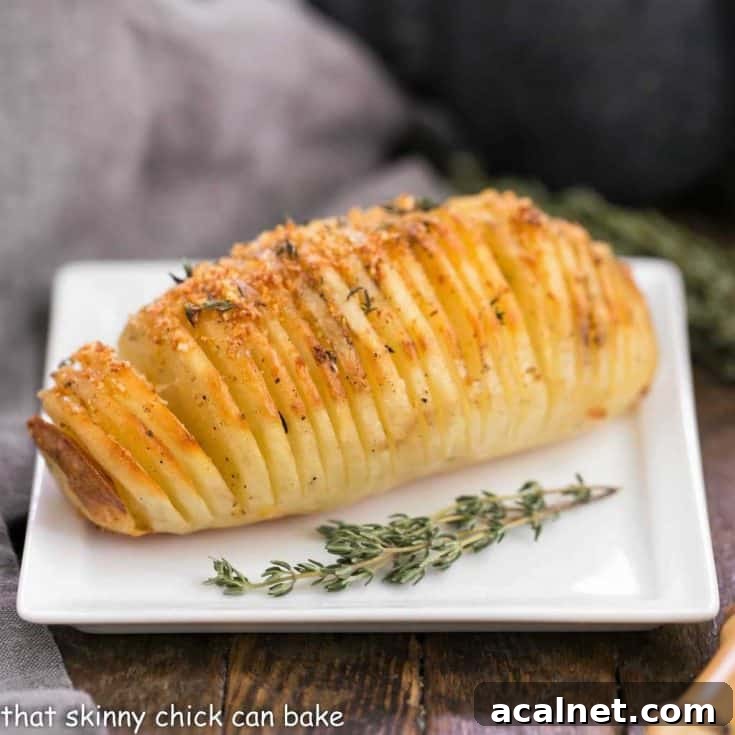 Hasselback Potatoes on a white plate with thyme garnishes