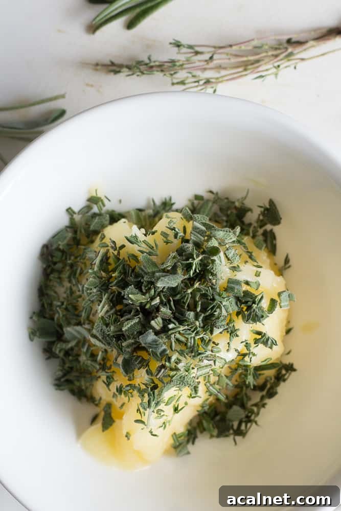 Spatchcocked Whole Turkey Smoked on a Traeger Grill 7 Chopped fresh herbs on top of softened ghee in a white bowl.