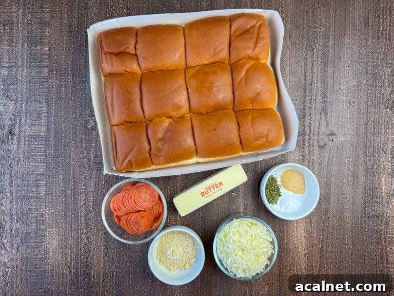 Ingredients to make easy pepperoni stuffed Hawaiian rolls are a package of Hawaiian rolls, sliced pepperoni, butter, garlic powder, Italian seasoning, salt, Italian cheese, and parmesan cheese on a wooden counter top.