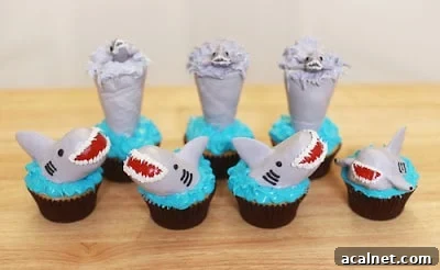 Chocolate cupcakes with blue frosting and smiling shark heads on top