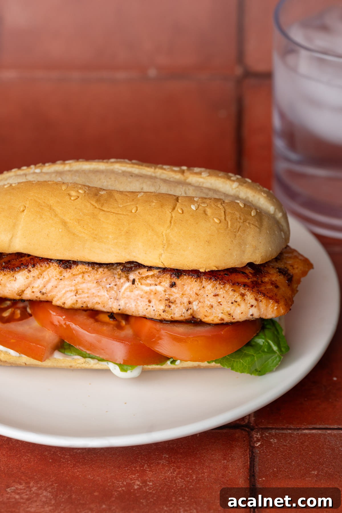 Sandwich with pan-fried salmon, lettuce, tomato, and tartar sauce.