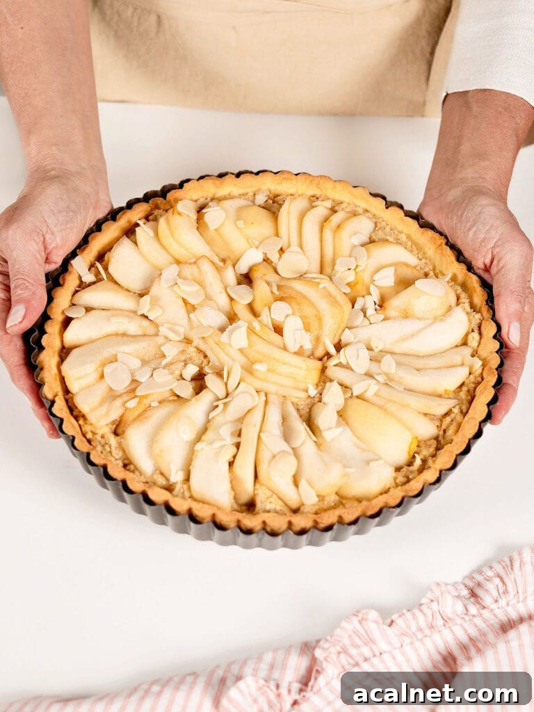 Holding pear tart ready to bake. White background.