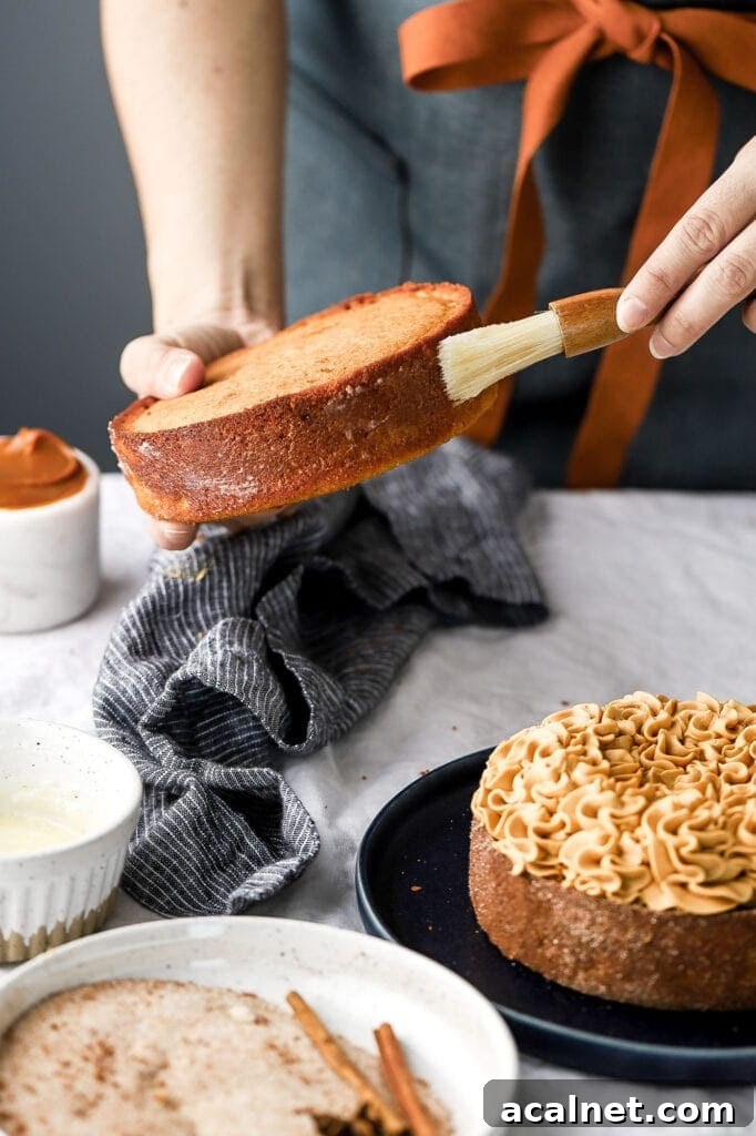 Apple Cider Donut Cake with Dulce de Leche Frosting — Autumn Dessert 3 brushing melted butter onto cake