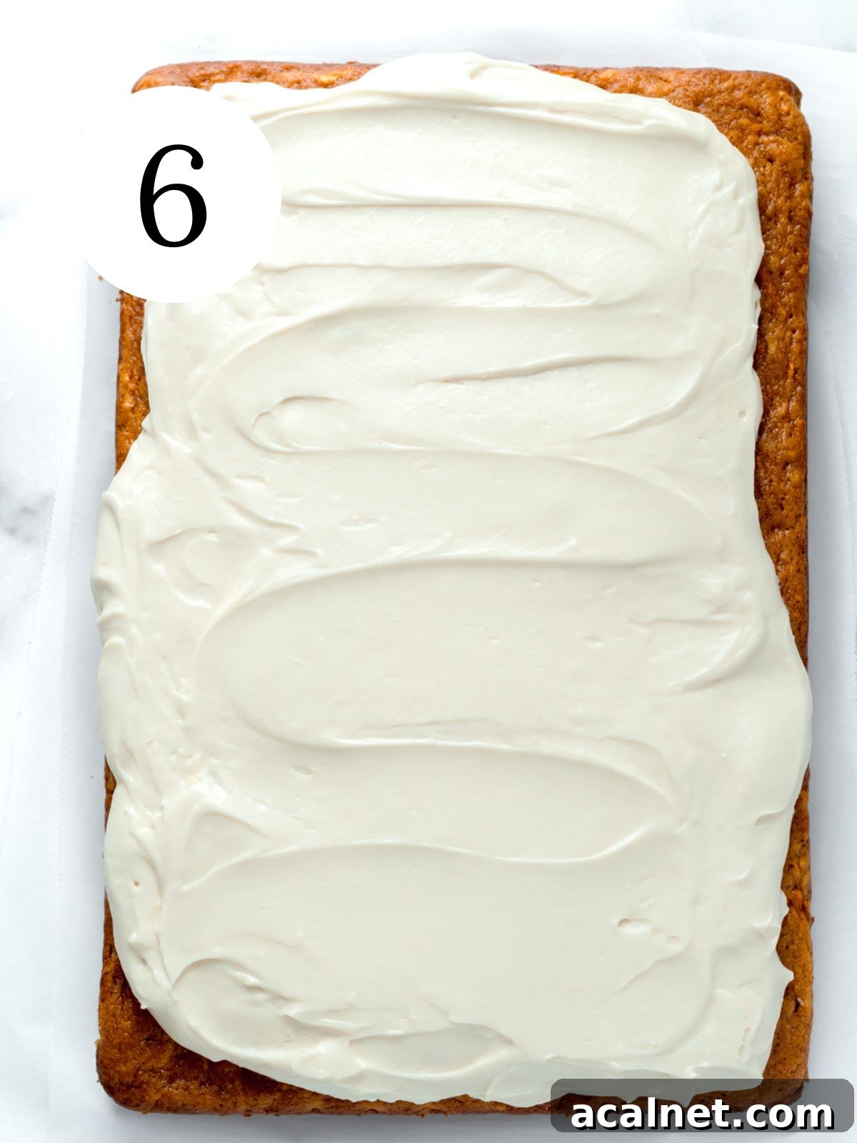 A pumpkin carrot cake with frosting spread on top. 