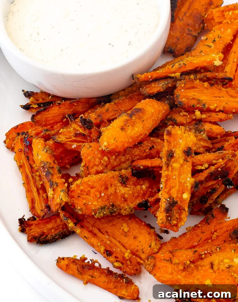Crispy smashed carrots served on a plate next to a small bowl of ranch. 