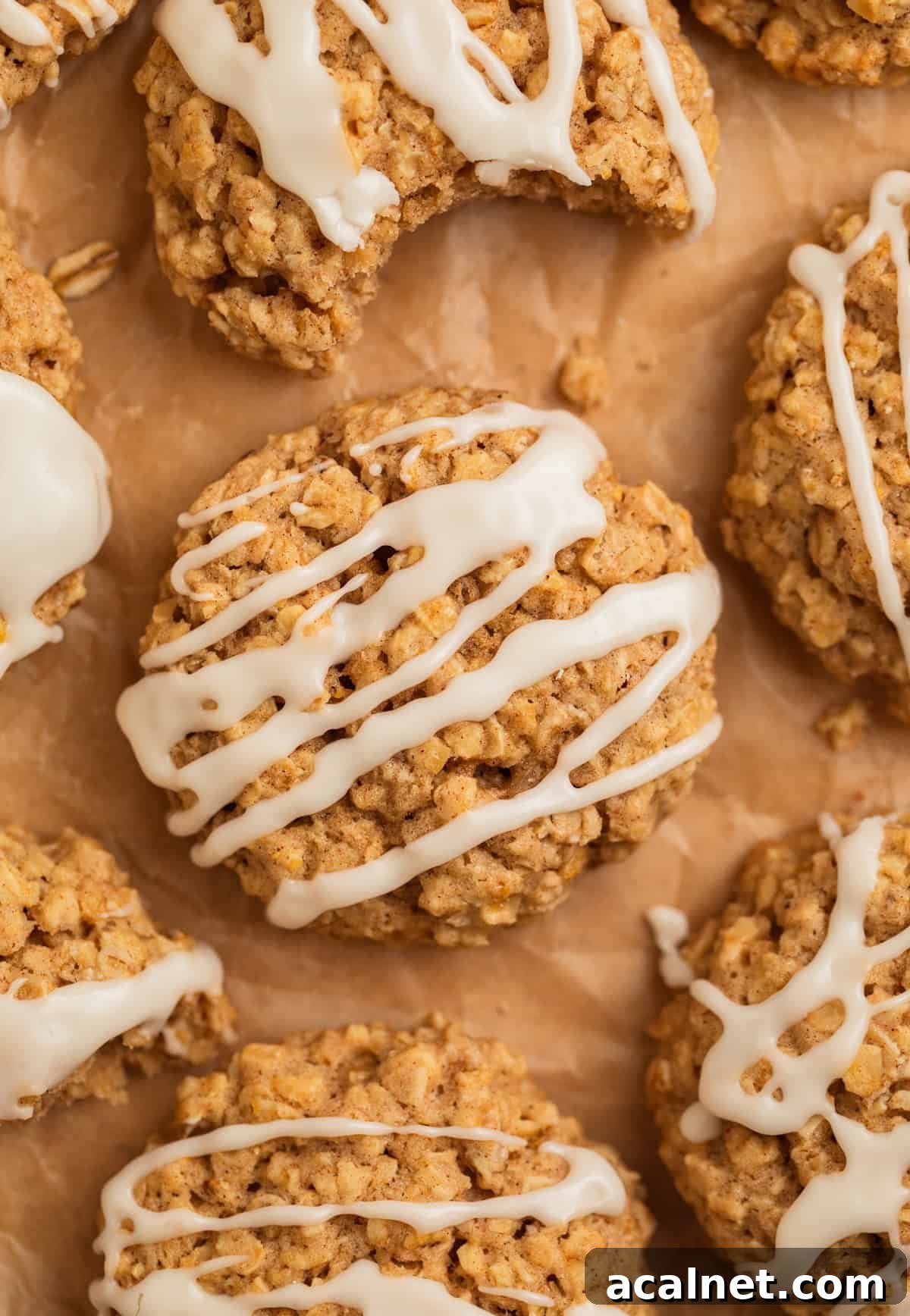 Cinnamon oatmeal cookies with icing drizzle on parchment.