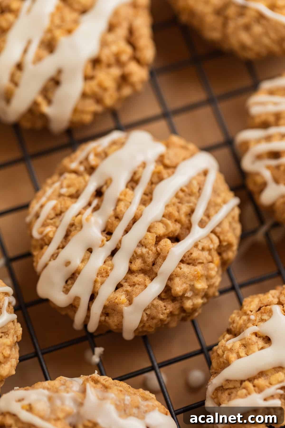 Oatmeal cinnamon cookies on cooling rack with icing drizzled over top.